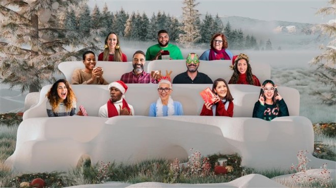 Together mode in Microsoft Teams with people in Christmas themed clothing sitting in 3 rows with a wintery background of snow and trees